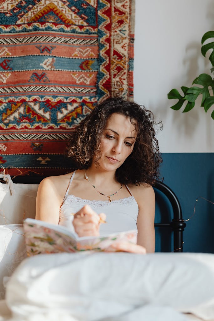 Woman Sitting in Bed and Writing in a Journal. Month energy for June is 2, awakening to your own spiritual understandings