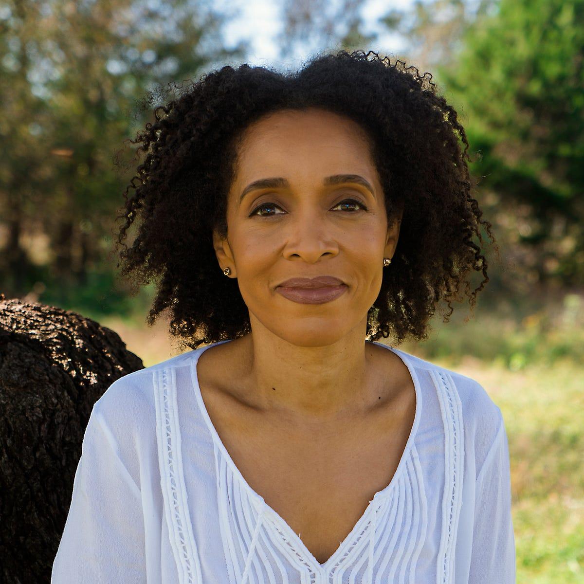 Woman with a gentle, thoughtful expression in warm natural light