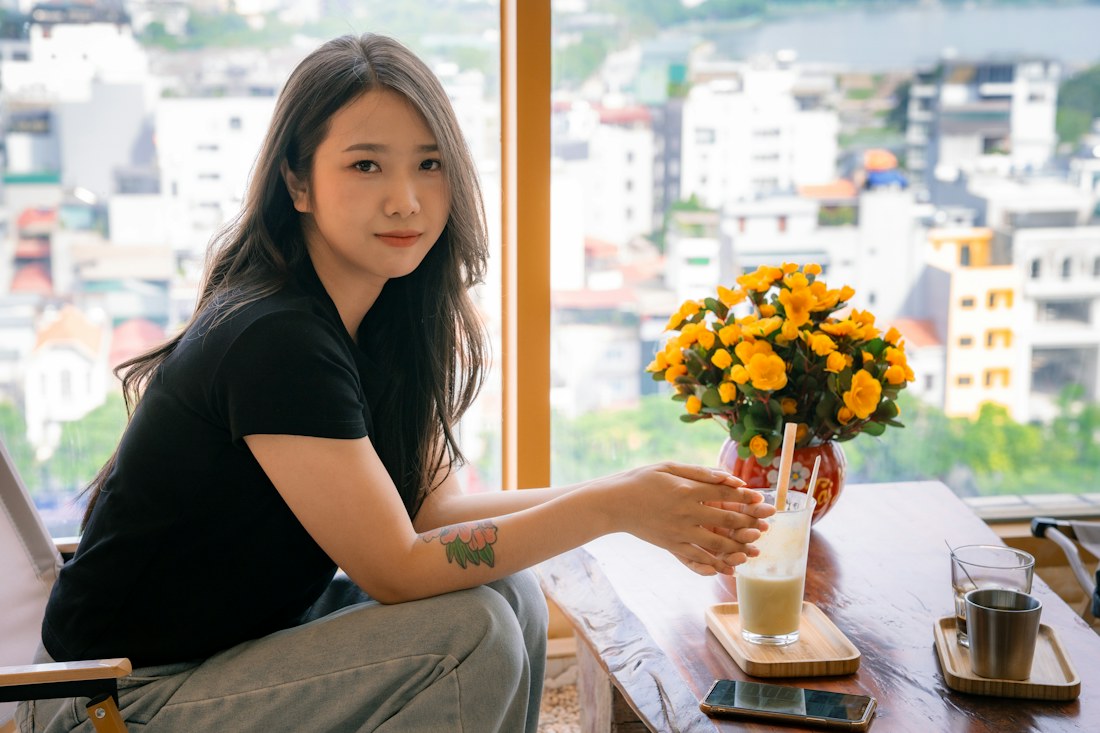 Woman seated at a cafe table enjoying a quiet moment